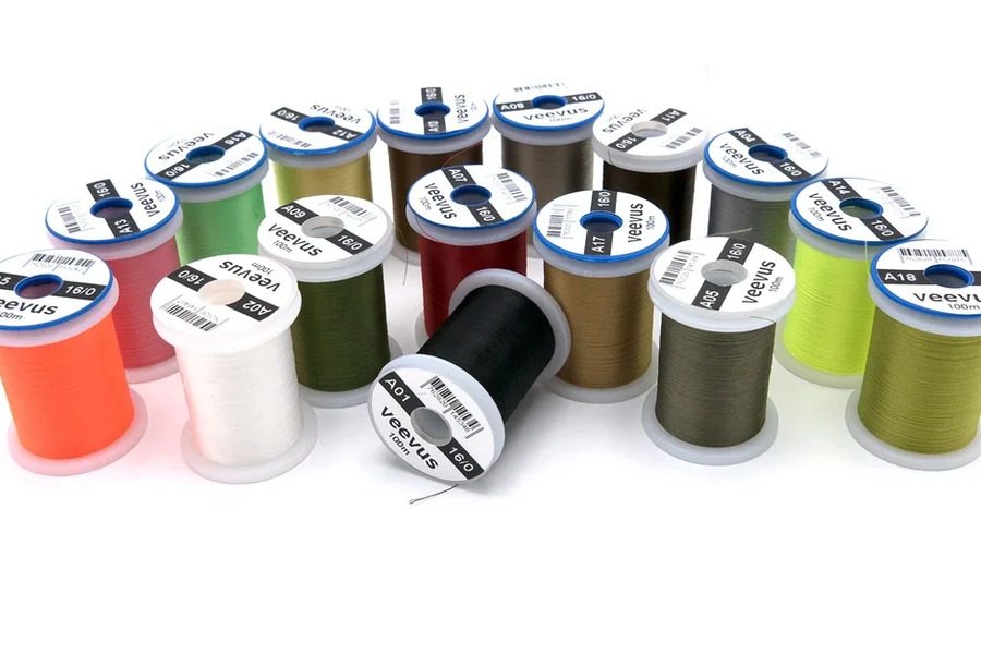 A curved row of VEEVUS thread spools in many colors